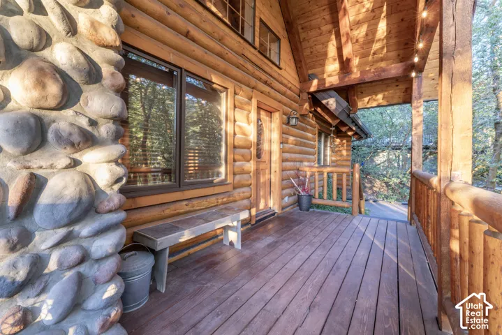 Wood-clad exterior with a stone-accented pillar, covered porch, and solid wood entry door