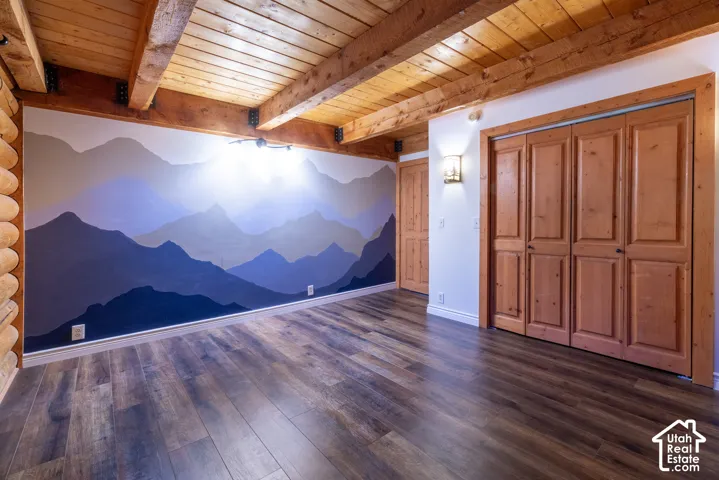 Exposed wood beam ceiling, wood-finish flooring, wood bi-fold doors, and a decorative wall mural