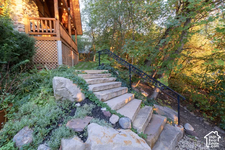 Stone exterior featuring a wood-plank balcony with lattice skirting