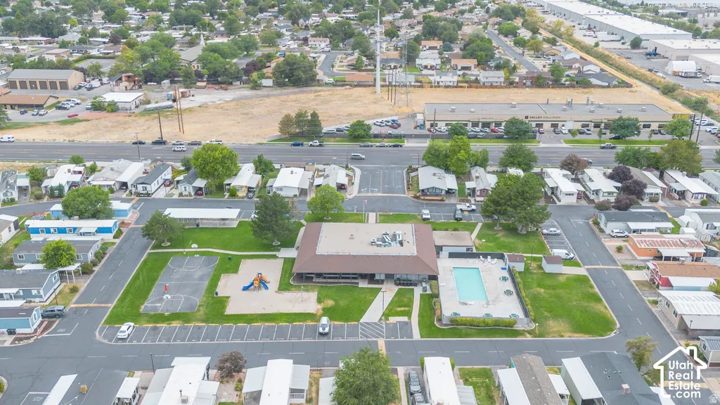 Community amenities featuring a central building, outdoor swimming pool, paved parking areas, and green spaces