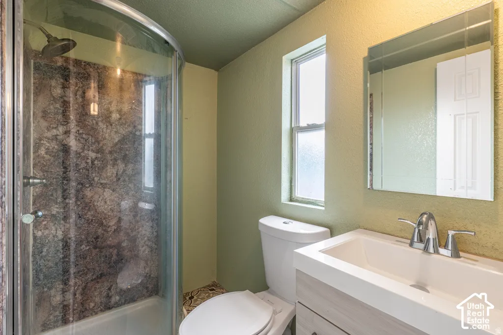 Curved glass shower enclosure with a dark-toned shower surround
