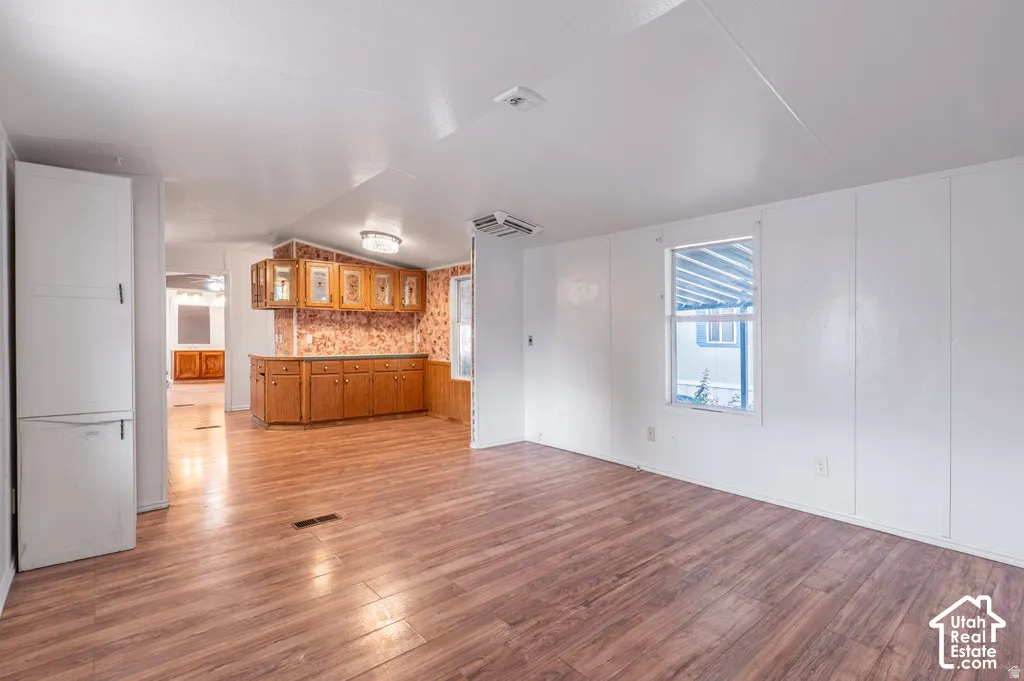 Wood-finish flooring throughout, white paneled walls, and a recessed window