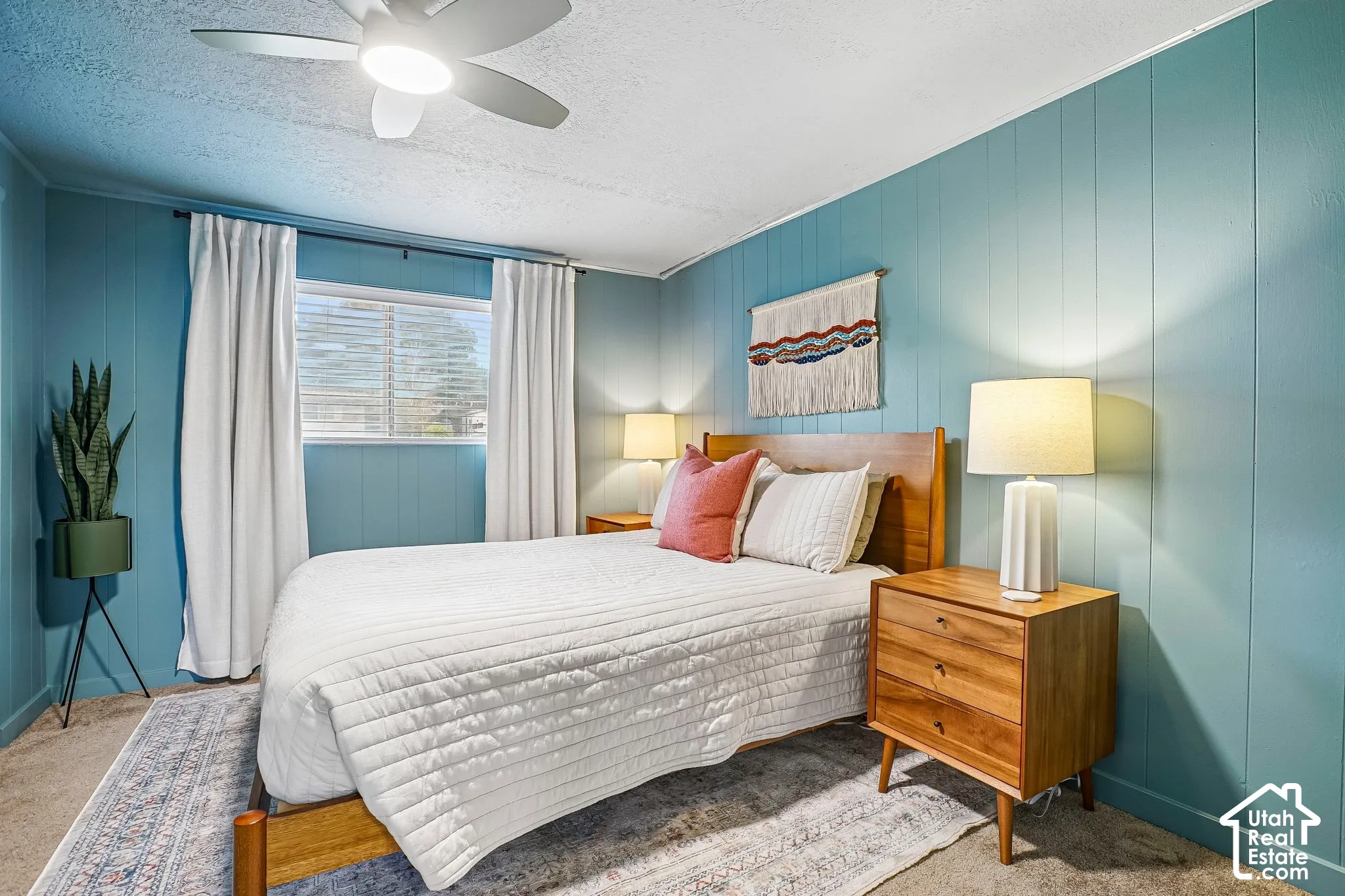 Wall paneling, window with blinds, ceiling fan with integrated lighting, wood-finish flooring