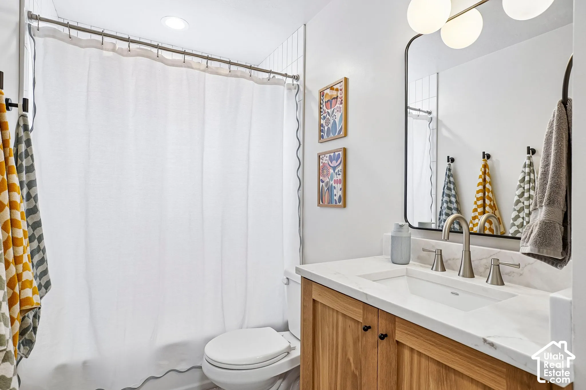 Wood-finish vanity with a white rectangular sink and brushed nickel faucet