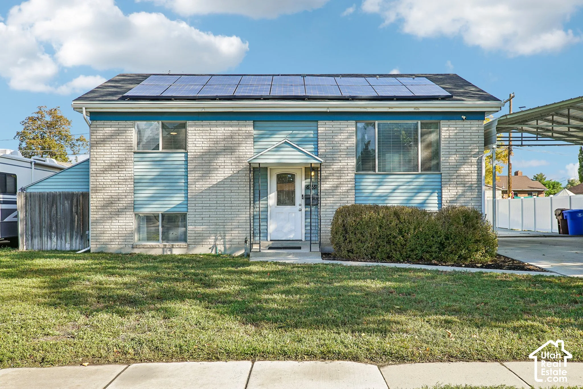 Stone veneer and siding exterior with solar panels and a covered carport