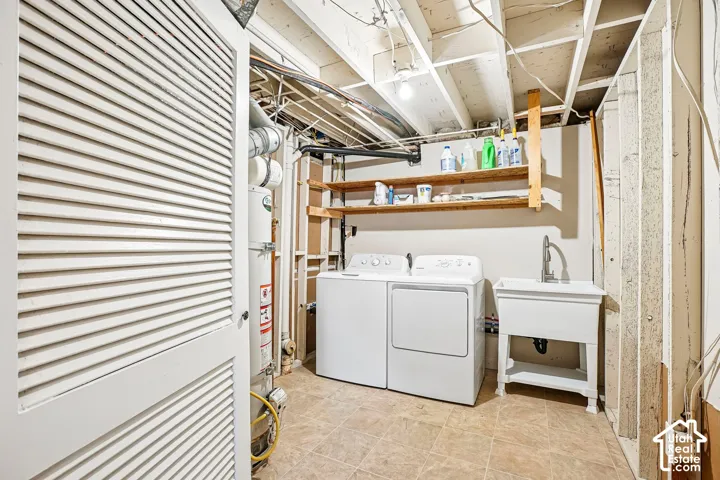 Louvered utility doors with a water heater, utility sink with a high-arc faucet, and wood shelving