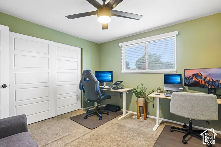 Carpeted flooring, ceiling fan with integrated lighting, window with horizontal blinds, and white sliding closet doors