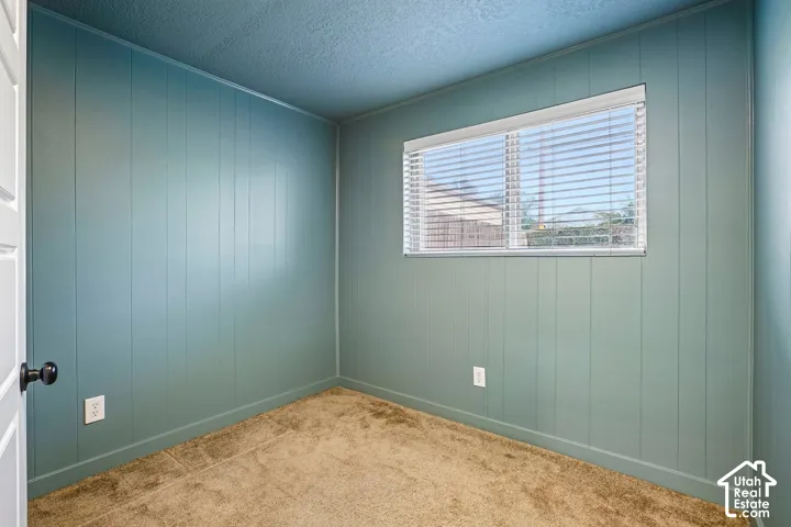 Paneling walls with a window featuring blinds