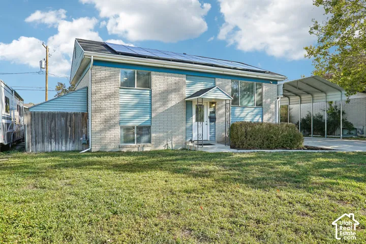 Brick and siding exterior with solar panels, covered entry, and an attached carport