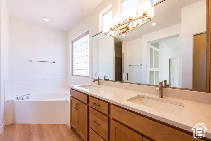 Dual vanity with light wood-finish cabinetry, integrated sinks, and light-toned countertops