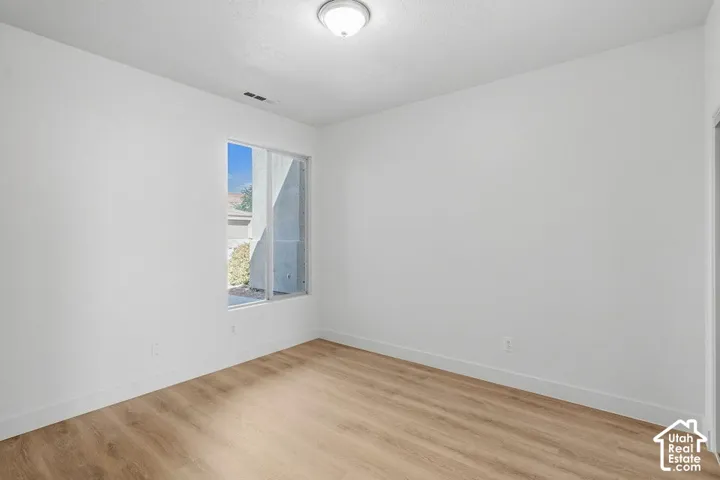 Light-filled room featuring wood-finish flooring and a ceiling-mounted light fixture