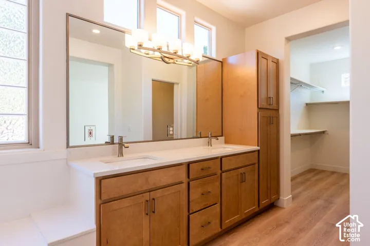 Dual vanity with light wood-finish cabinetry, white countertop, and brushed nickel fixtures