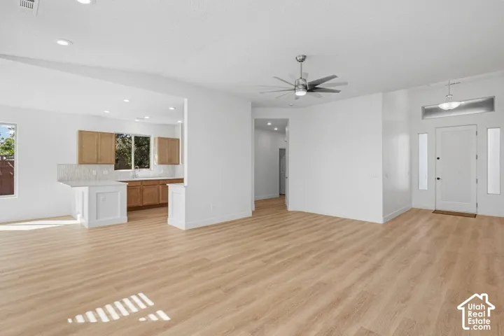 Open-concept living space featuring wood-finish flooring, recessed lighting, and a modern ceiling fan