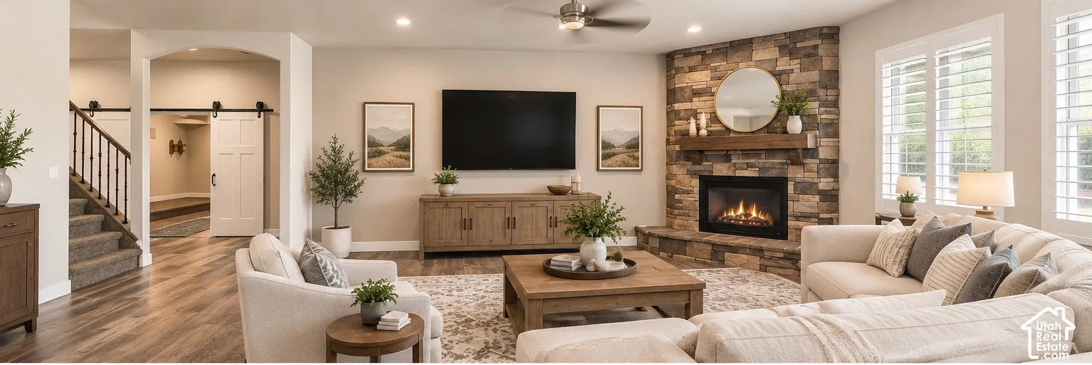 Family Room with Corner stone fireplace with a timber mantel, wood-finish flooring, recessed lighting, ceiling fan, and plantation shutters