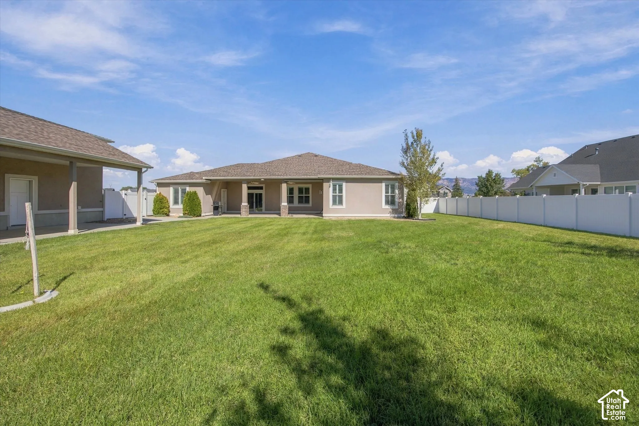Expansive green lawn with a white privacy fence, 2 covered patios