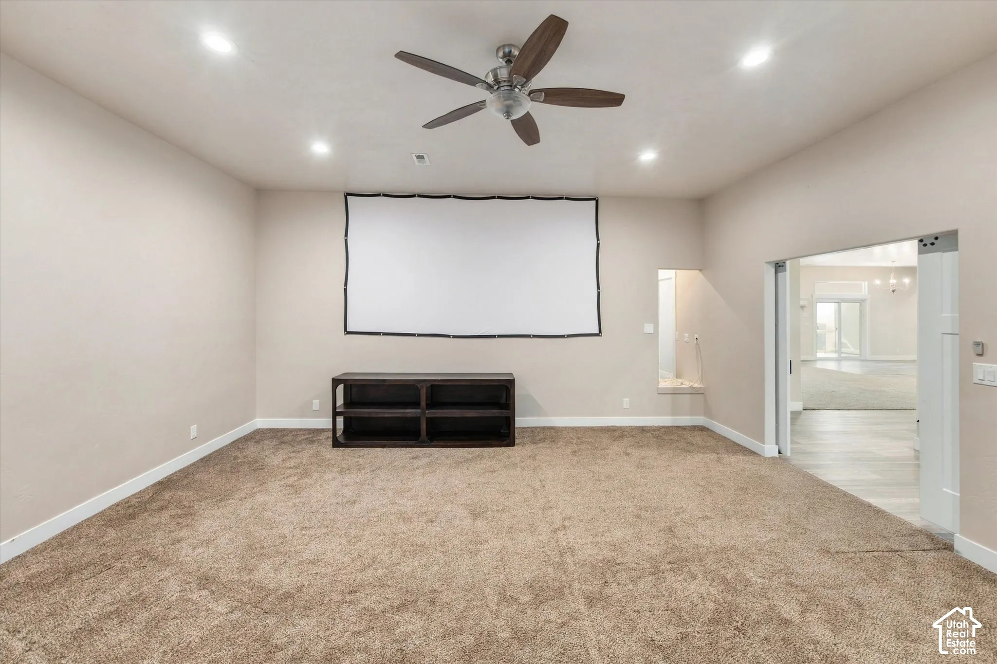 Room featuring a ceiling fan with integrated lighting, recessed overhead lighting, a built-in media console, and a large projection screen