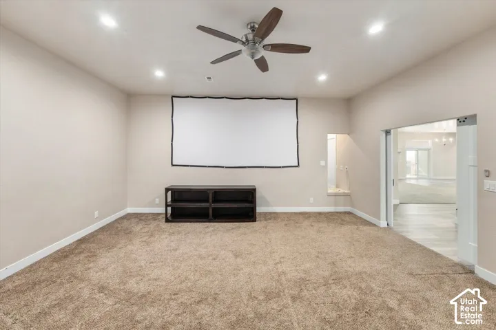 Room featuring a ceiling fan with integrated lighting, recessed overhead lighting, a built-in media console, and a large projection screen