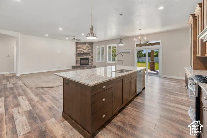 Kitchen island with granite countertop, stainless steel sink, and pendant lighting