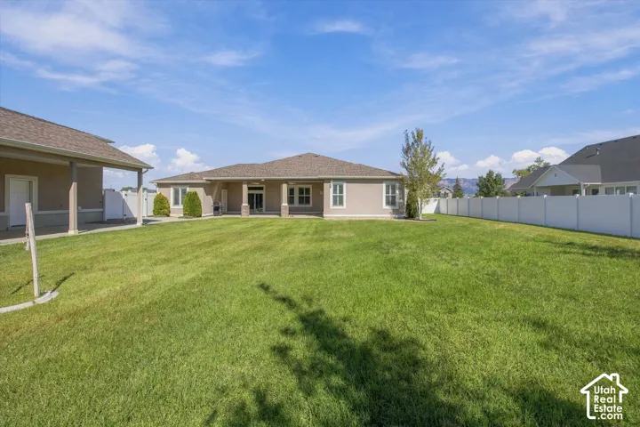 Expansive green lawn with a white privacy fence, 2 covered patios