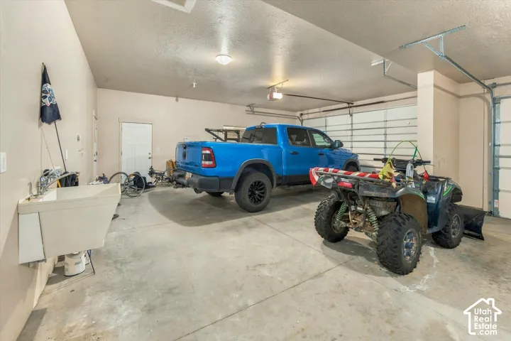 attached 4-car garage,utility sink, and overhead lighting