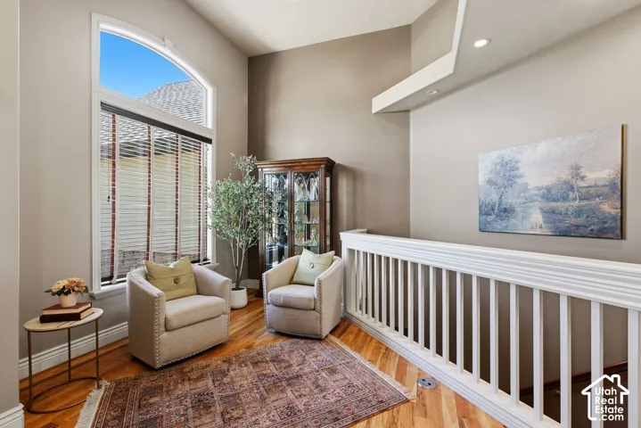 Welcoming entryway with warm hardwood flooring and sitting area