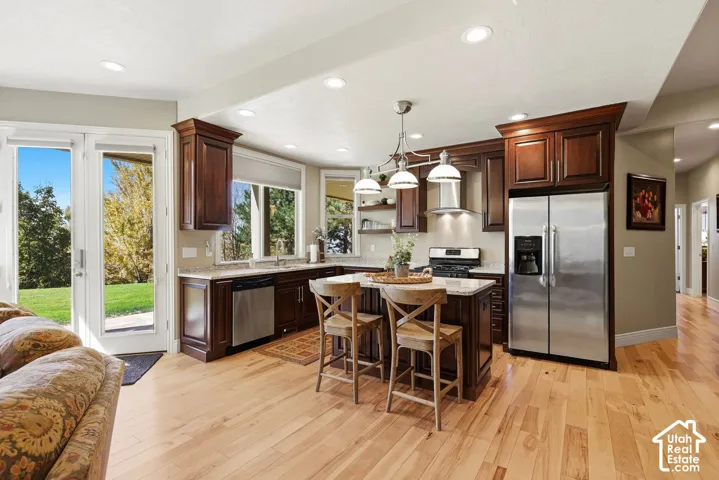 Lower level kitchen with stainless steel appliances, island, and solid surface countertops
