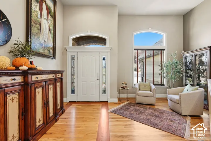 Welcoming entryway with warm hardwood flooring and sitting area