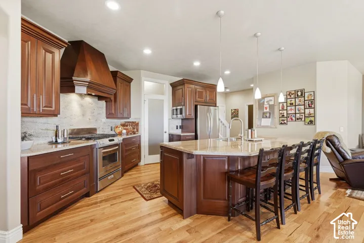 Open kitchen with stainless steel appliances, walk in pantry, hardwood floors and open to the family room