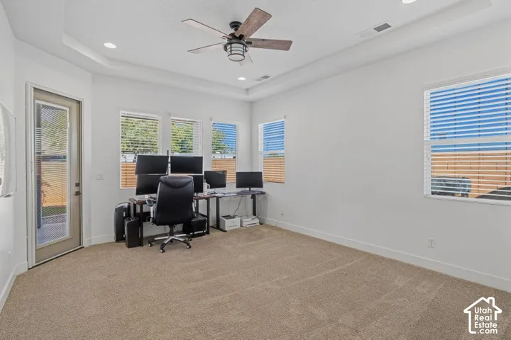Recessed lighting, ceiling fan, multiple windows with blinds, and neutral carpet flooring