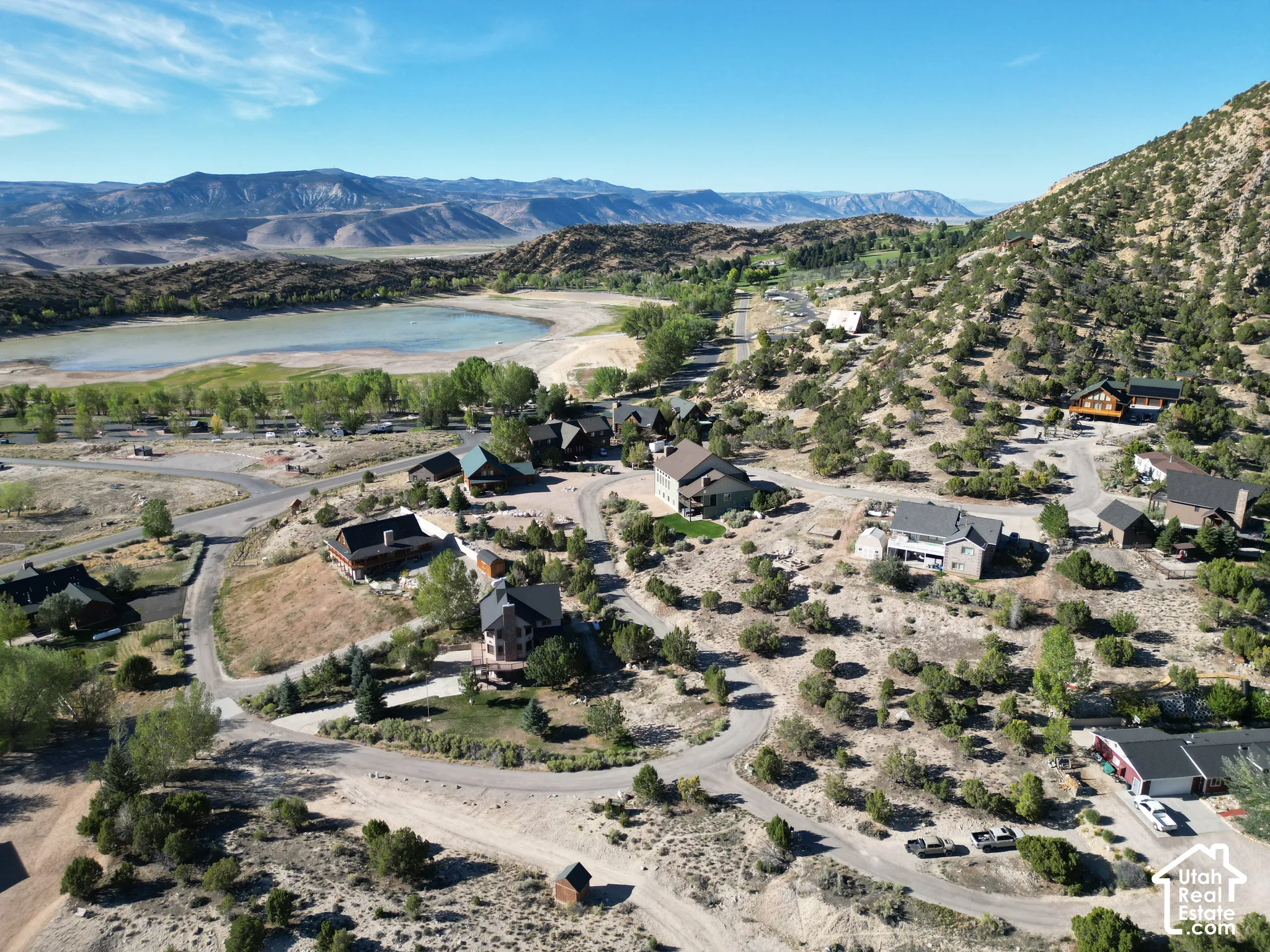 Expansive mountain terrain with scattered residences and a prominent body of water