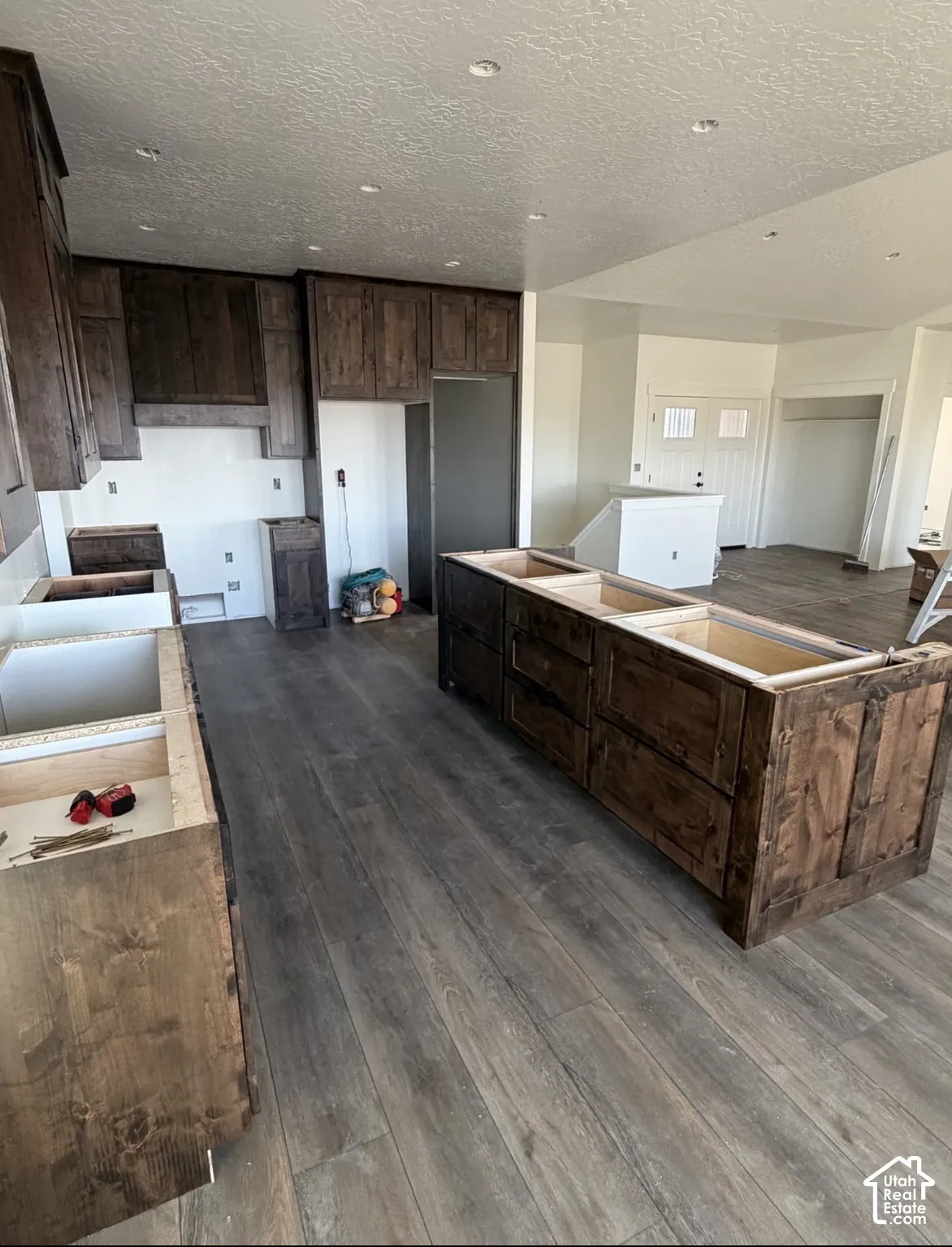 Kitchen area featuring wood-finish flooring, dark wood cabinetry, and recessed lighting