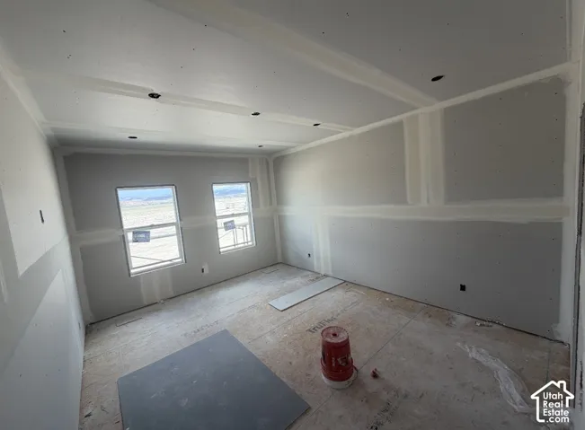 Room under construction featuring two windows, recessed ceiling lights, and unfinished walls