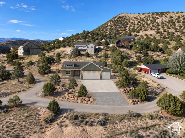 Contemporary ranch-style residence featuring a two-car garage, concrete driveway, and a gravel circular drive