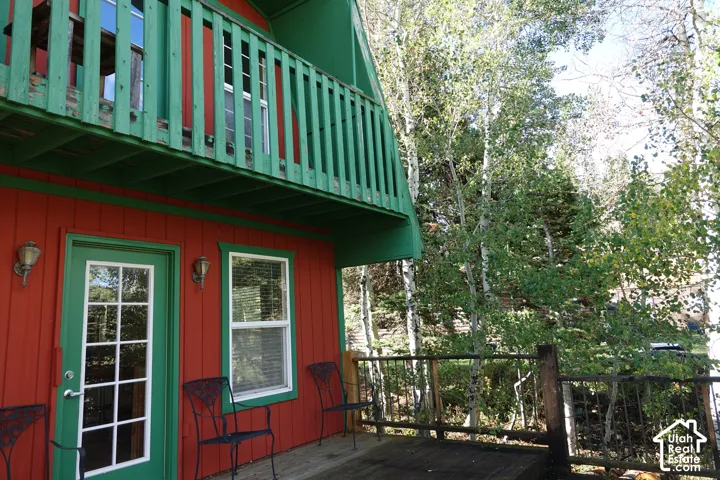 Exterior featuring board and batten siding, a full-lite door with grid-patterned glass, and an upper-level balcony