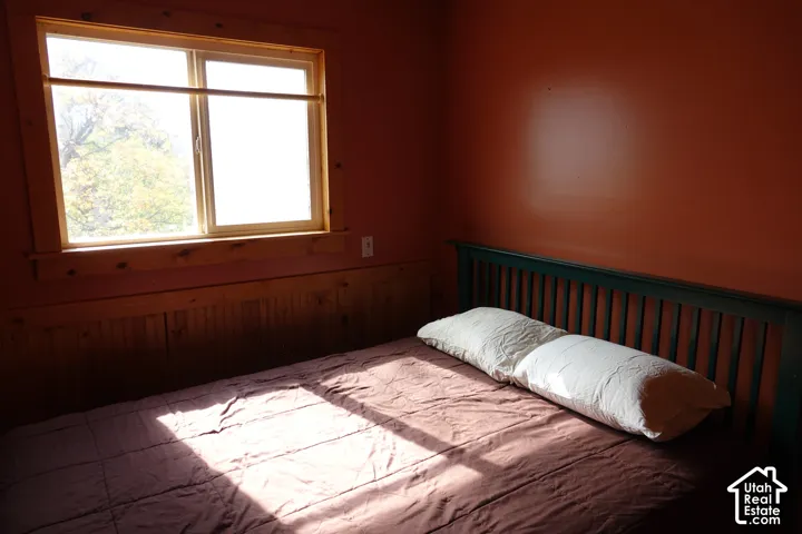Wood-framed window, natural wood wainscoting, and orange painted walls