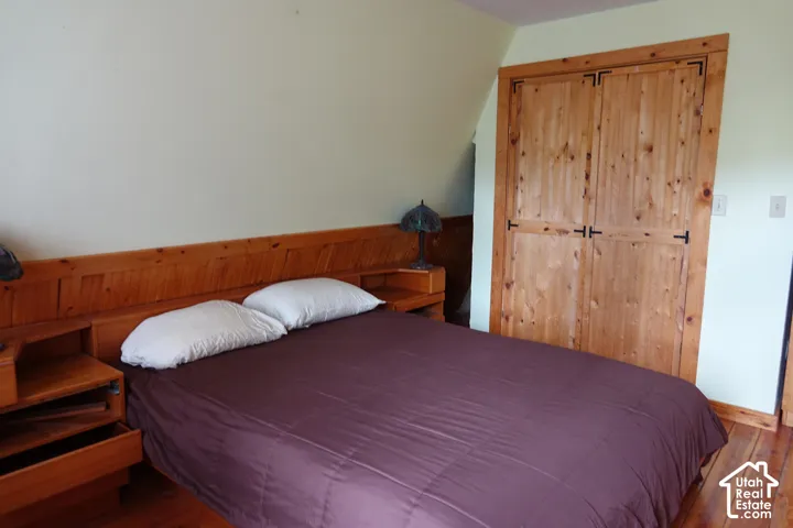 Wood-finish flooring with coordinating built-in headboard and integrated side tables