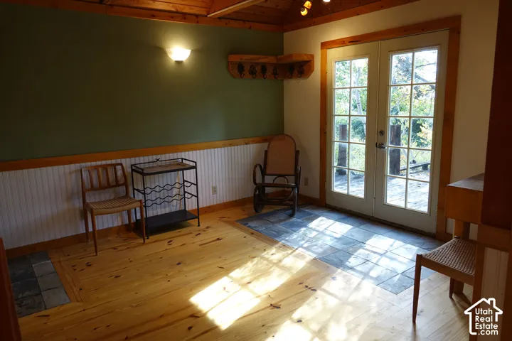 Wood flooring with slate tile inlay, beadboard wall paneling, and a wood-paneled ceiling