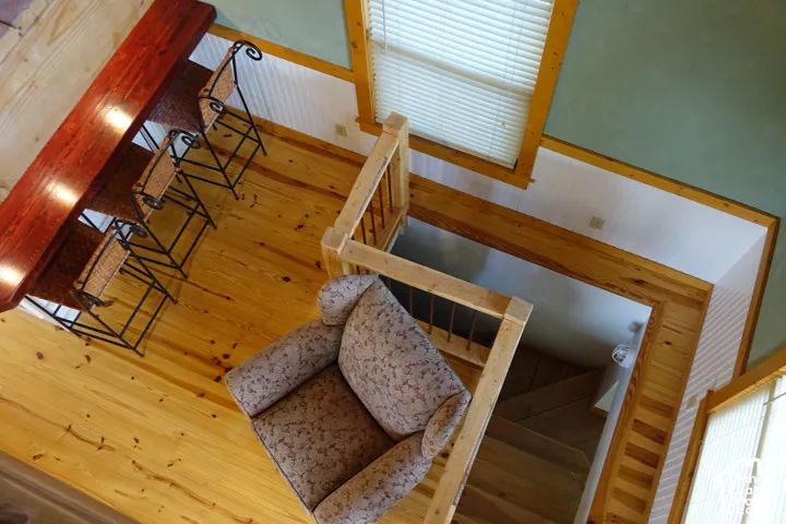 Wood flooring throughout, wood-paneled walls, and a built-in wood bar