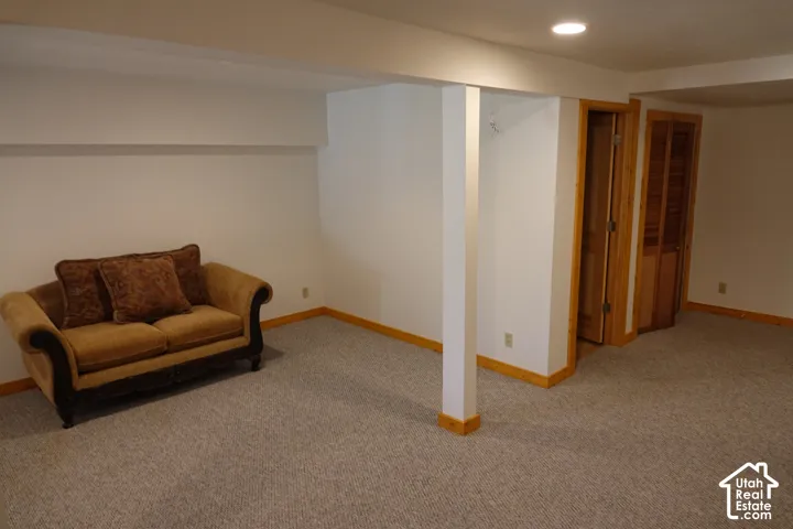 Carpeted room with recessed lighting and natural wood trim