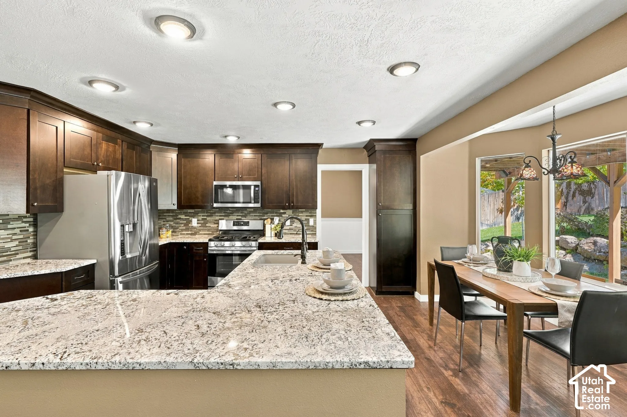 Spacious kitchen featuring rich wood-finish cabinetry, stainless steel appliances, and light-toned countertops