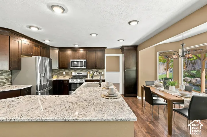 Spacious kitchen featuring rich wood-finish cabinetry, stainless steel appliances, and light-toned countertops