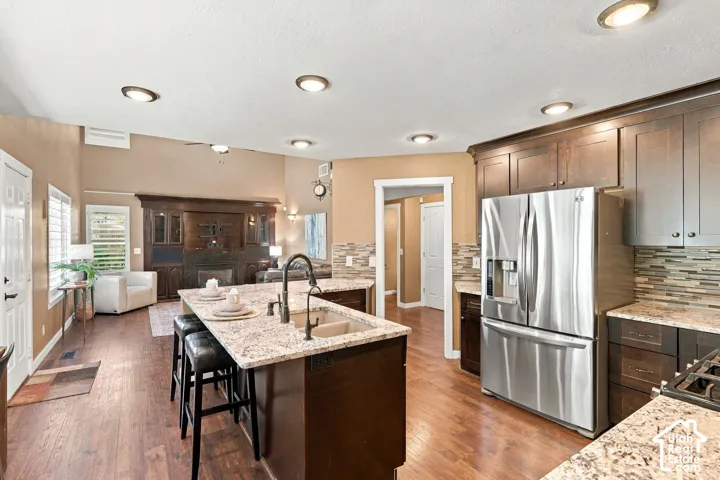 Spacious kitchen with wood-finish flooring, granite countertops, and dark wood cabinetry