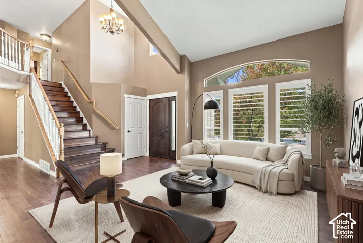 Two-story foyer with wood-finish flooring and a grand staircase featuring wood treads and white balusters