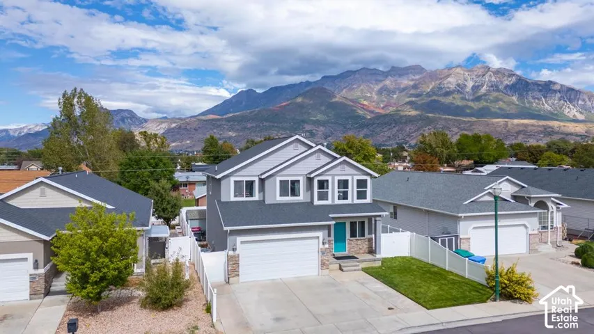 Two-story residence featuring a striking mountain backdrop, an attached garage, and a driveway