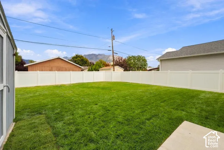 Expansive grassy yard with a privacy fence