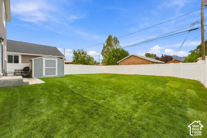 Expansive green lawn with a white privacy fence