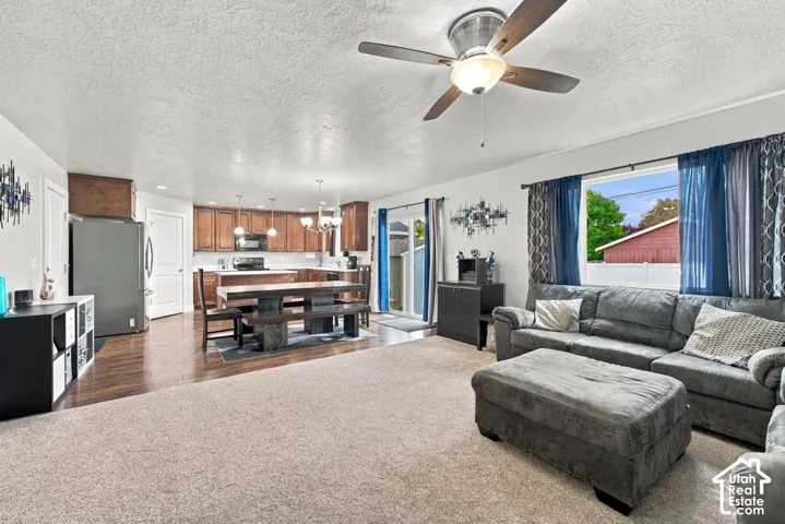 Open-concept living space with wood-finish flooring, recessed lighting, and a ceiling fan