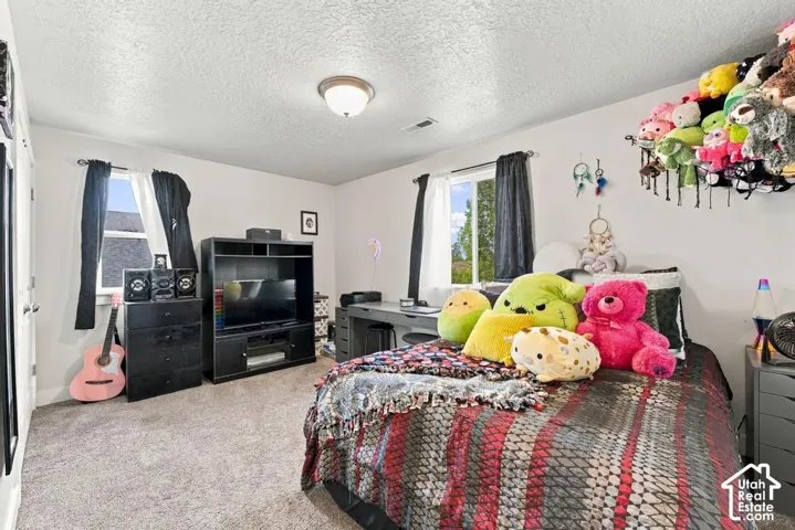 Carpeted flooring, recessed lighting, and dual windows provide ample illumination