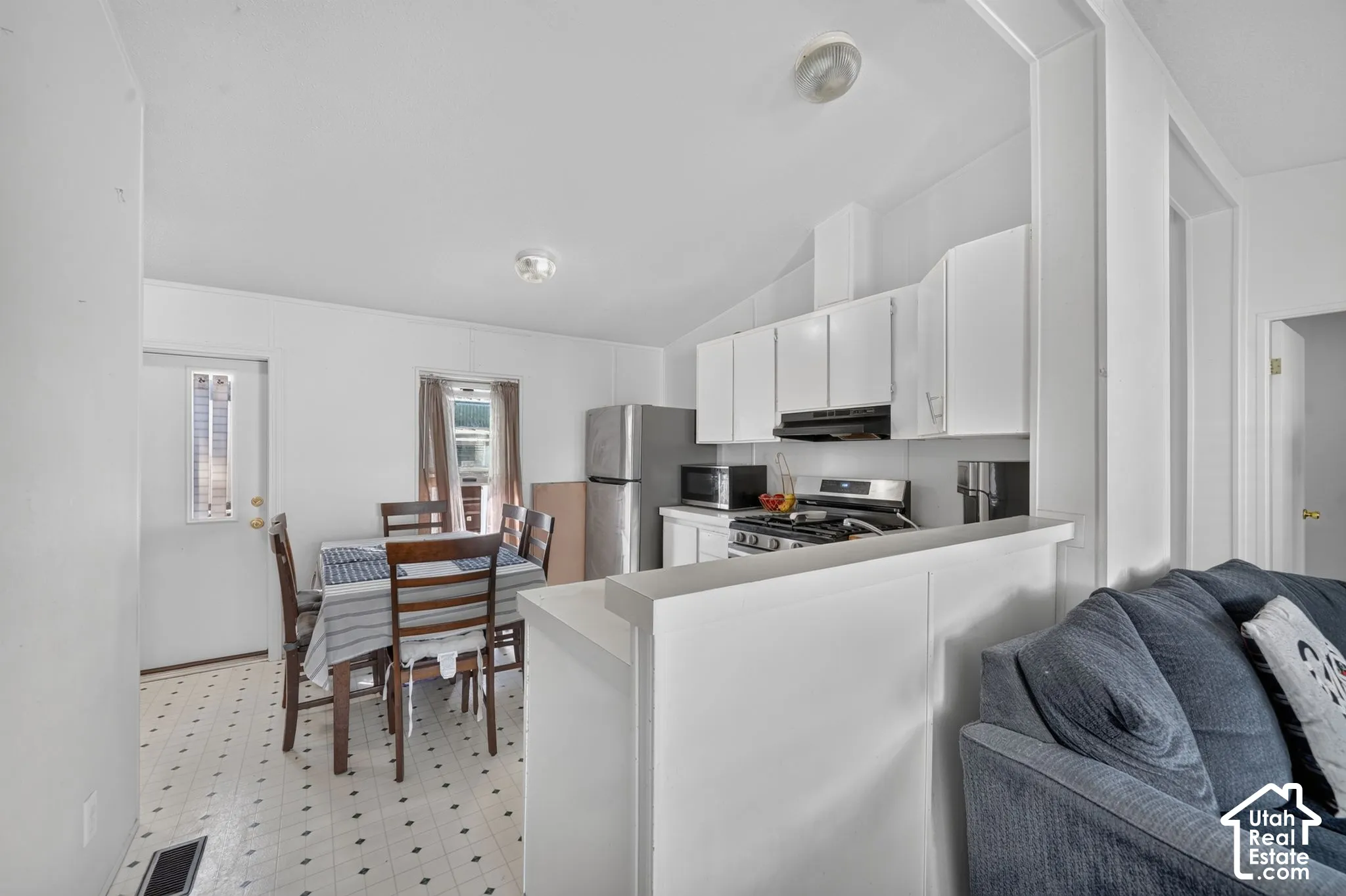 Kitchen featuring white cabinetry, stainless steel appliances, and a gas range