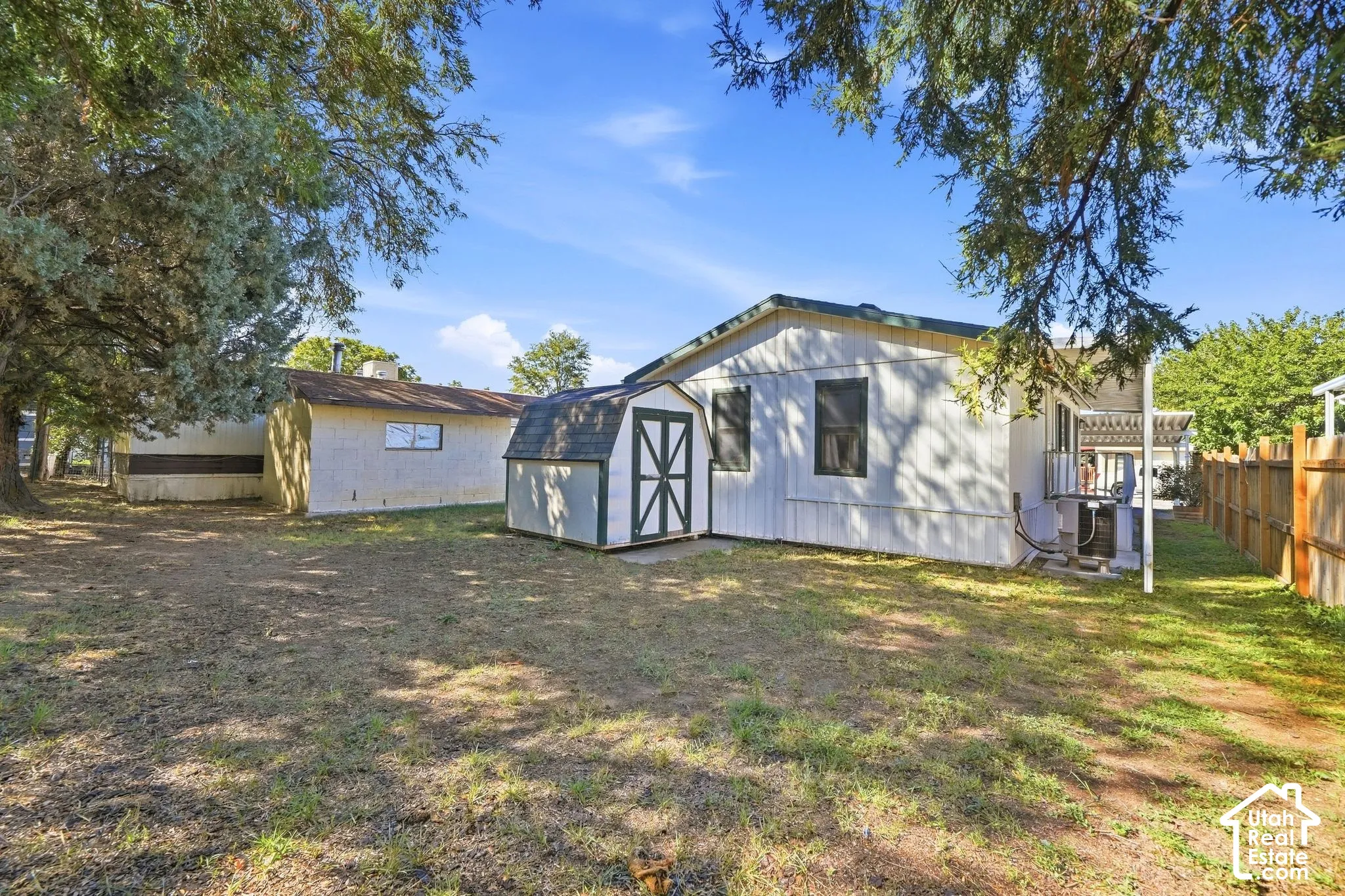 Expansive yard with a detached shed featuring a gabled roof and double doors
